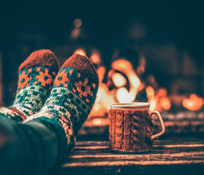 Feet in woollen socks by the winter fireplace